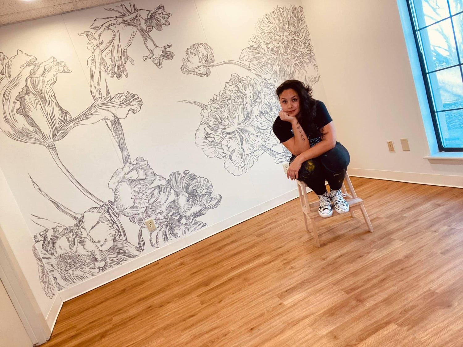 Woman sitting in front of a mural